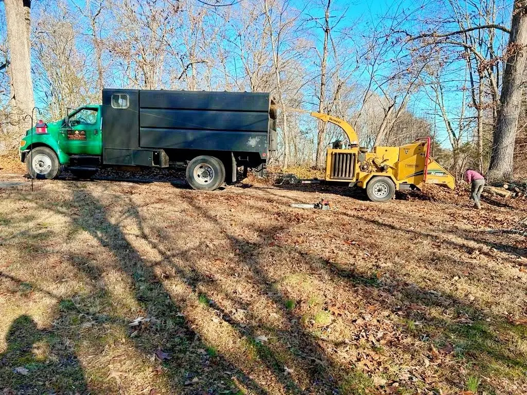 Chip truck and wood chipper set up in the woods on a Knoxville, TN job